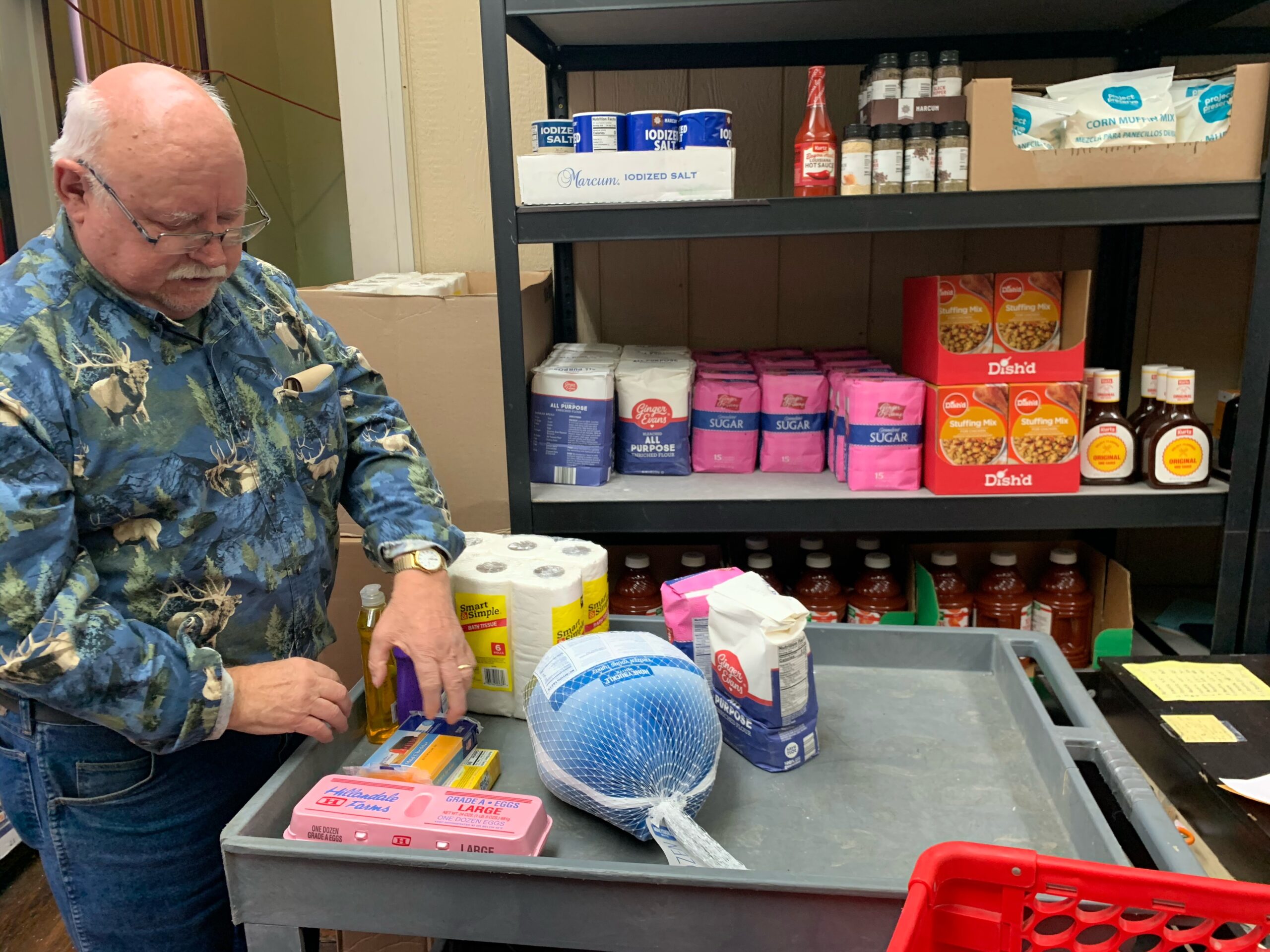 Director of the pantry, Tom Sollars, packages items for a local family. Sollars has been a volunteer at the pantry since it opened -- over 20 years.