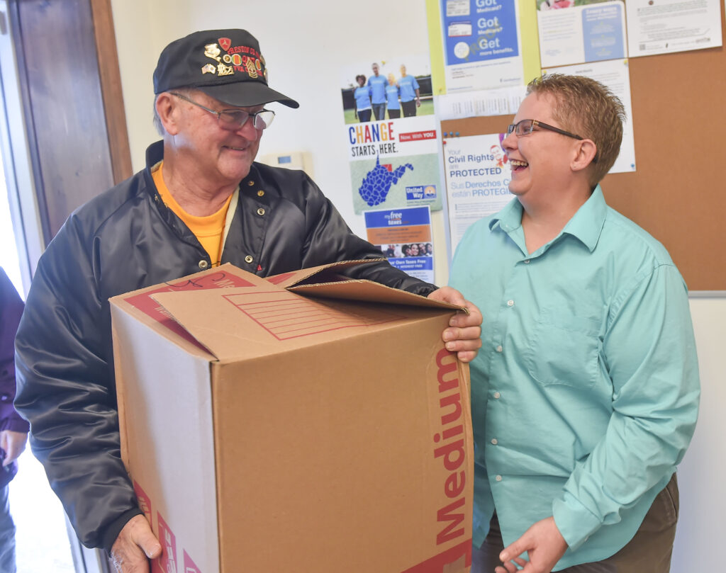Jim Savage with Post 977 hands Polly Williams of Community Action a box of food on Wednesday.