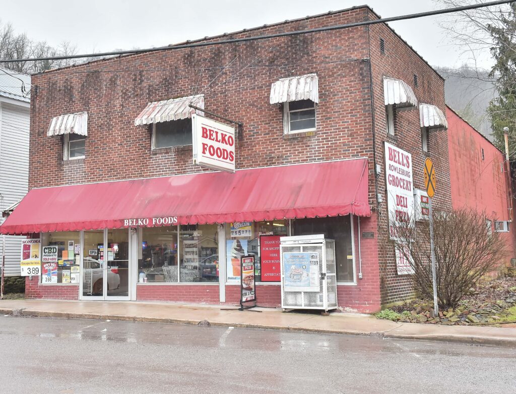 Red brick building with signs reading 'Belko Foods' & 'Bell's Grocery'