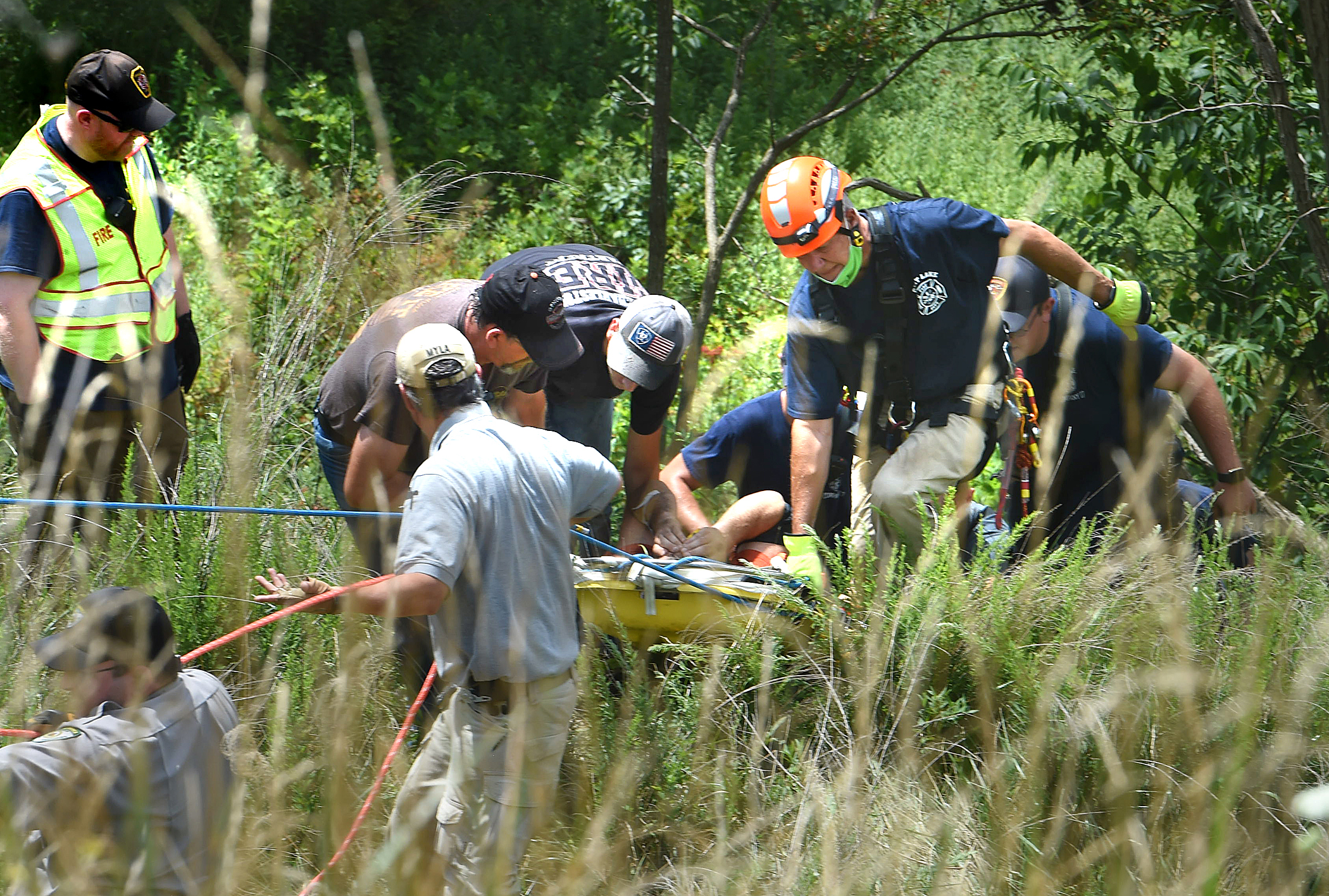 rescuers bring an injured man up the hill