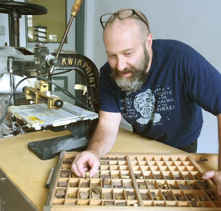 Neil Burton shows a drawer of metal letters.