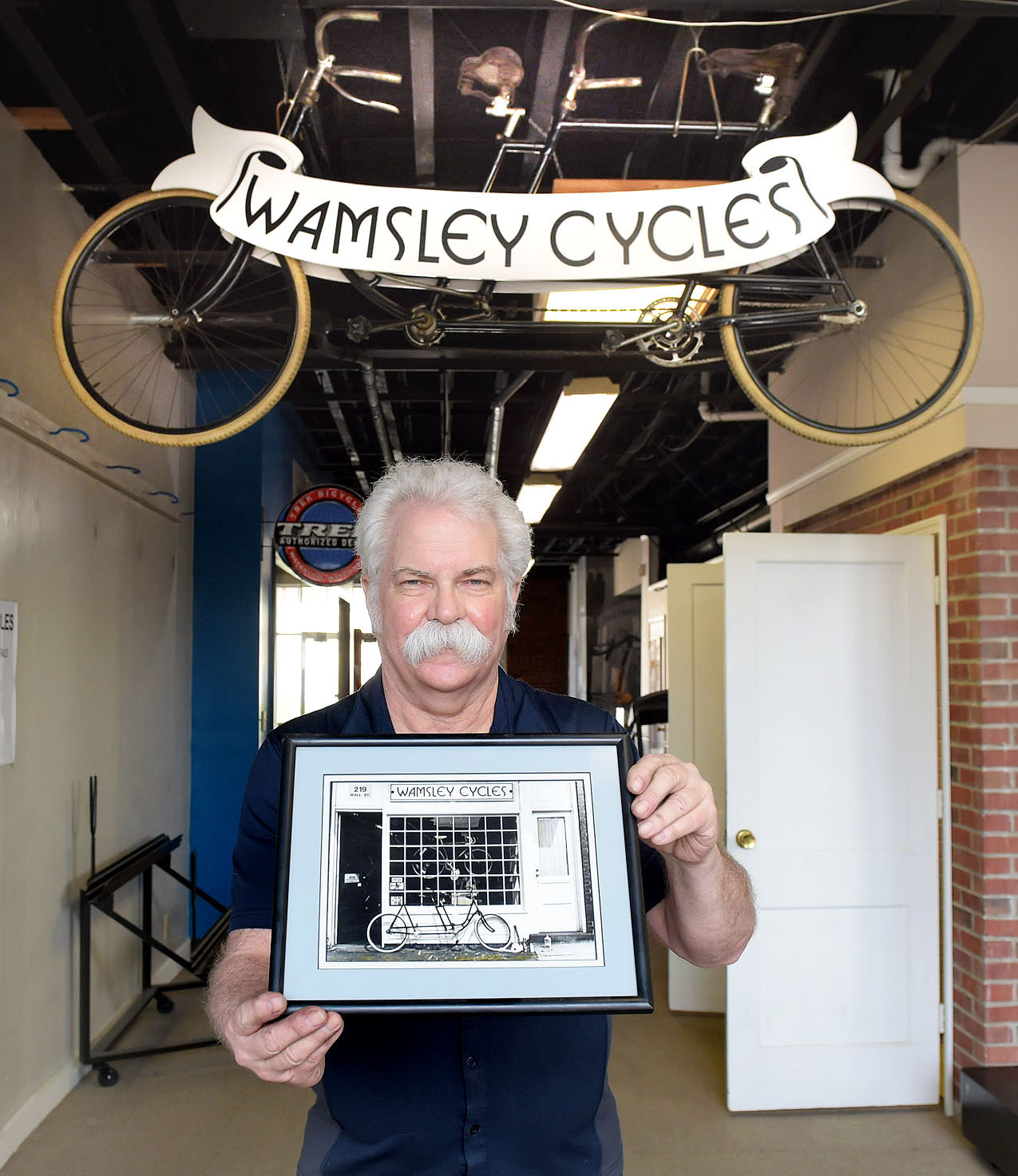 Chip Wamsley with photo of first shop