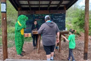 Community members participate in last year's Save The Frogs Day activities and meet Lloyd the Frog at Friends of Deckers Creek's Outdoor Learning Park. (Submitted photo)